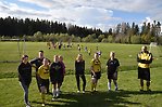 Fotbollsledare inom Storfors FF står framför en gräsplan där barn och ungdomar spelar fotboll.